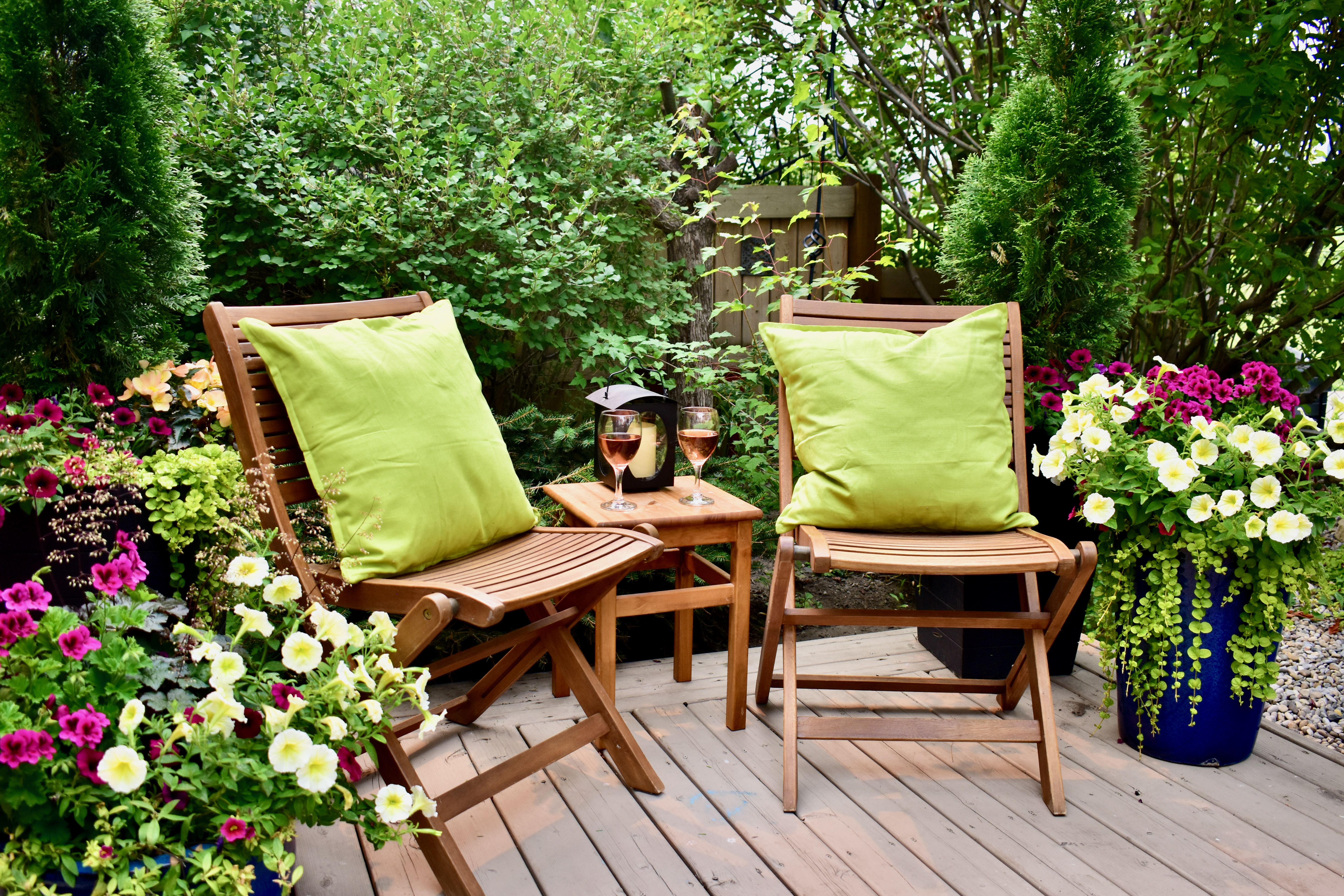 gemütliche Sitzecke im Garten mit Blumen auf einer holzterrase